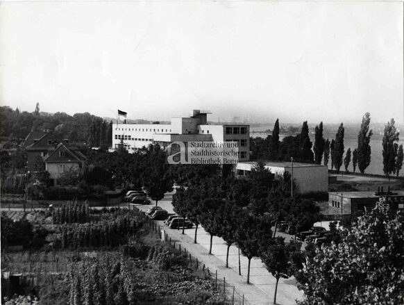 Blick aus erhöhter Position von Süden auf das Gebäude der Pädagogischen Akademie, über der die schwarz-rot-goldene Fahne weht, 1948/49